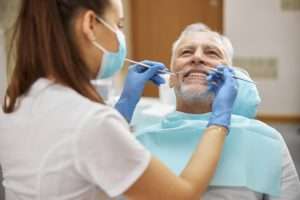 Dental specialist examining teeth of a senior citizen